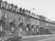 Maisons en rangées photographiées sur la rue Saint-Denis en 1975, au nord de la rue Roy. On y voit le cinéma Rex. Archives de la Ville de Montréal, VM6,R3115.1.