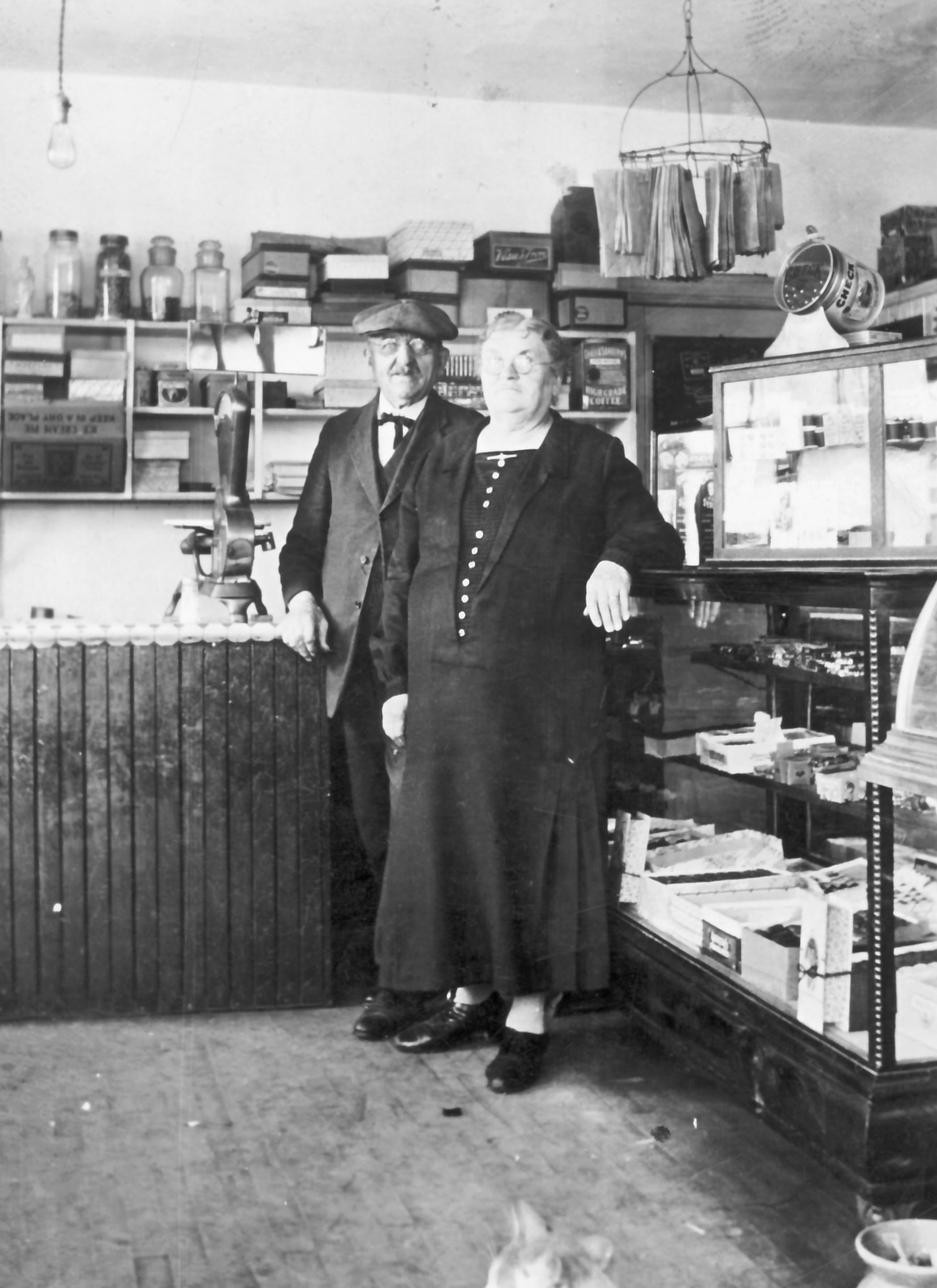 Photo en noir et blanc d’un couple âgées dans un commerce de tabac et bonbons.