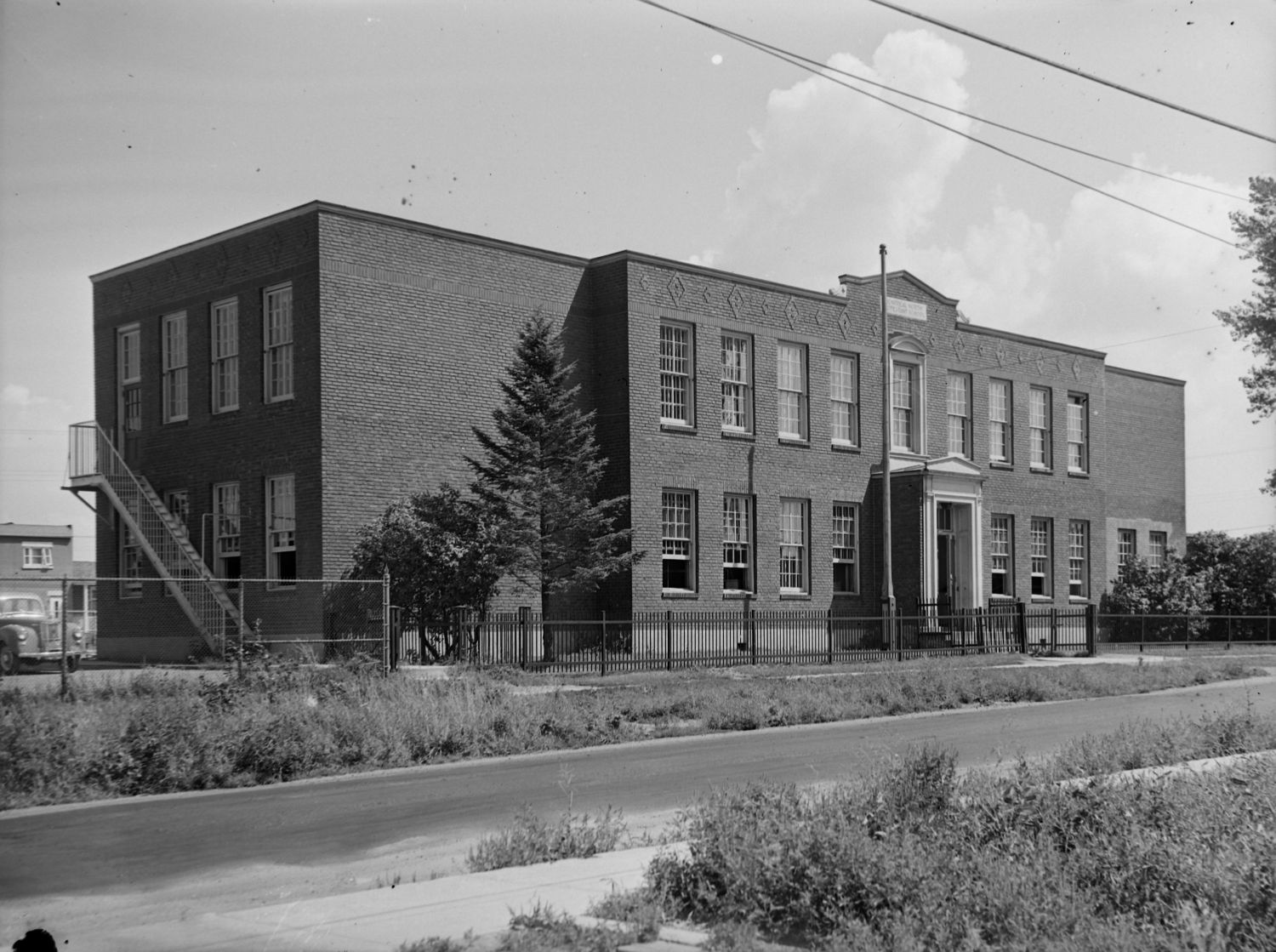 Nous voyons l'extérieur de l'école de briques « Sarah Maxwell Memorial School » située rue Préfontaine à Montréal.