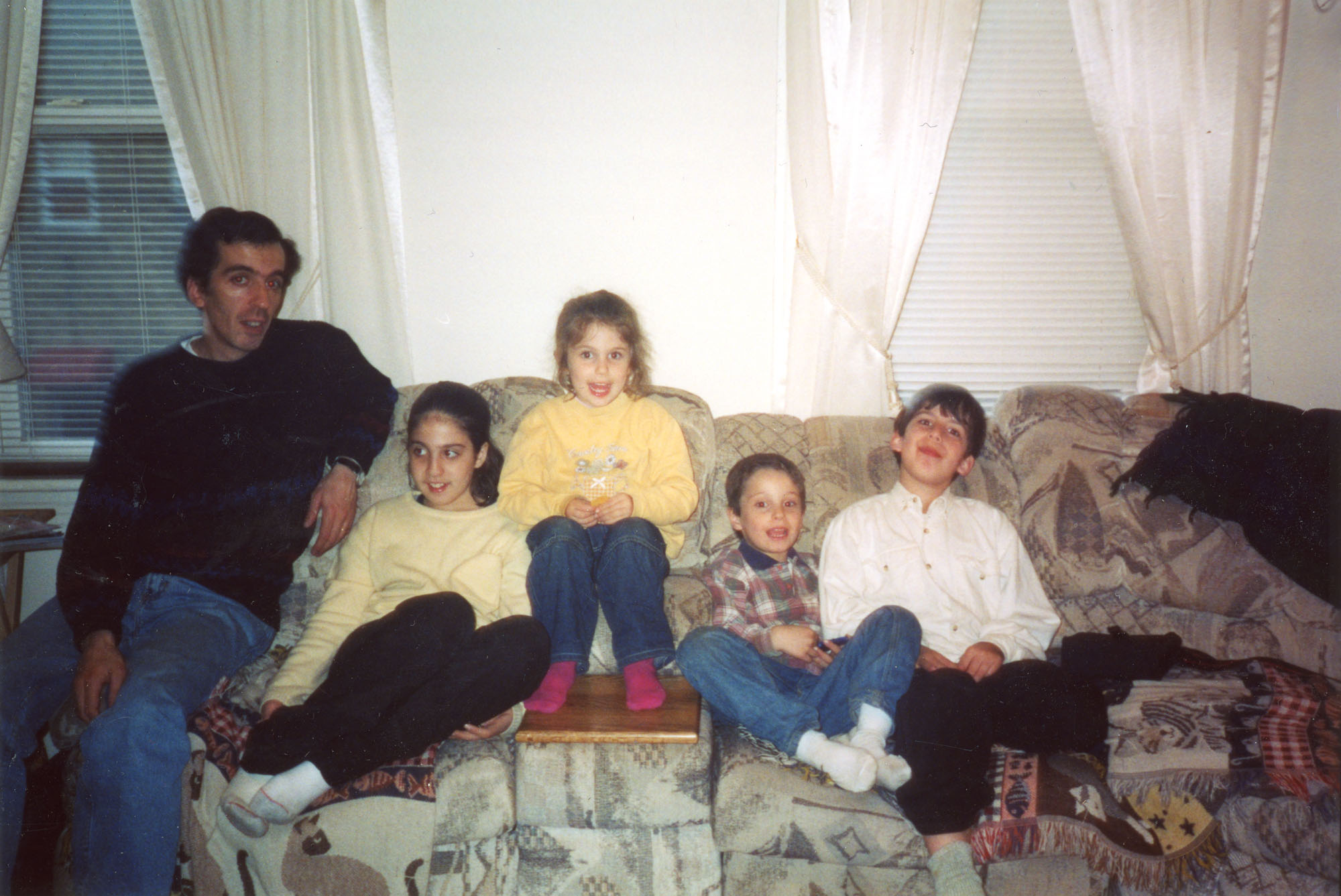 Une famille assise sur un divan.