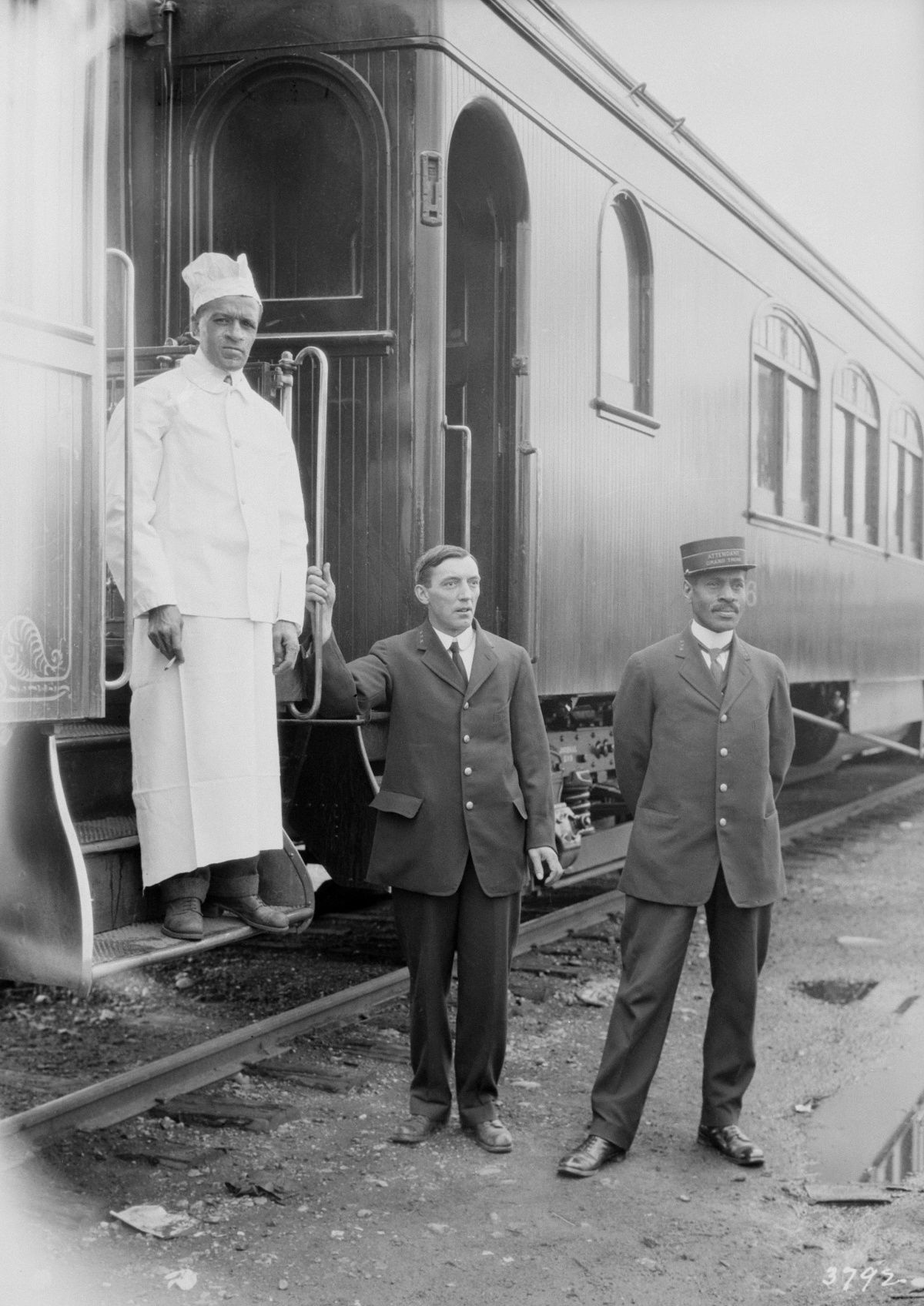 Trois hommes travaillant pour la Compagnie de chemin de fer du Grand Tronc posent devant un wagon