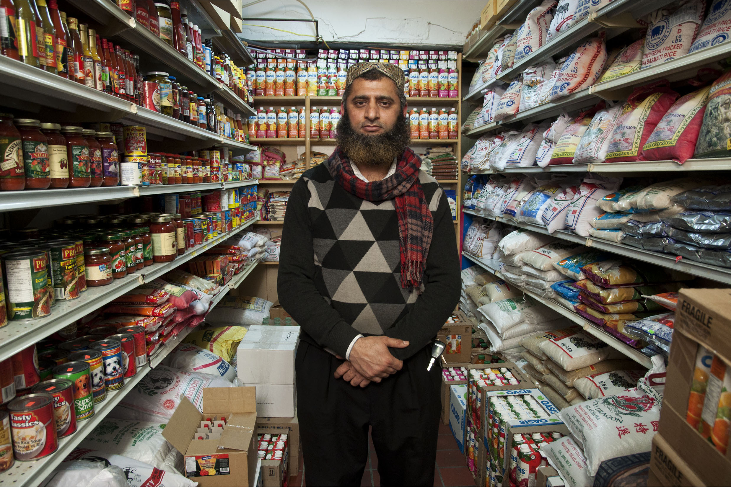 Un homme debout dans son épicerie pakistanaise