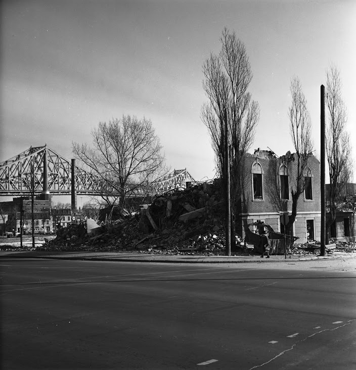 Bâtiment démoli dans le quadrilatère de Radio-Canada, avec le pont Jacques-Cartier en arrière-plan, 1963.