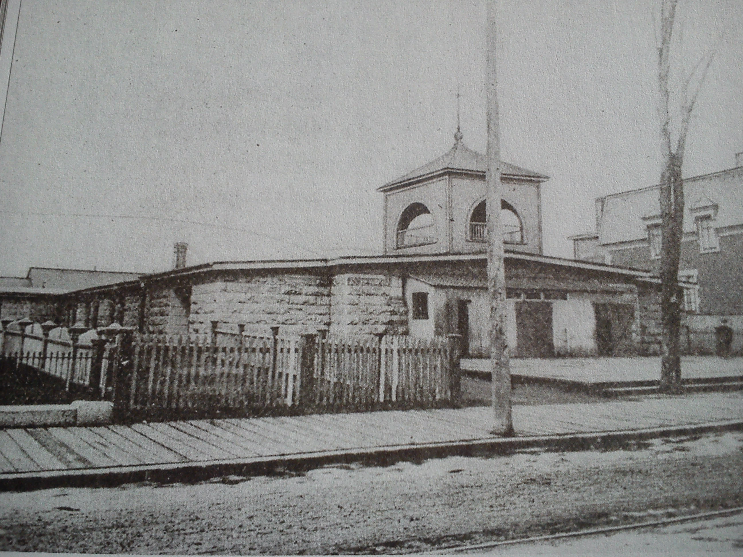 Photo ancienne d'un bâtiment coiffé d'un clocher de chapelle.