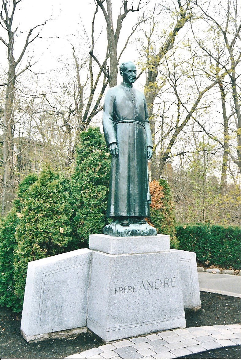 Photographie couleur de la statue du frère André avec des éléments naturels. autour.