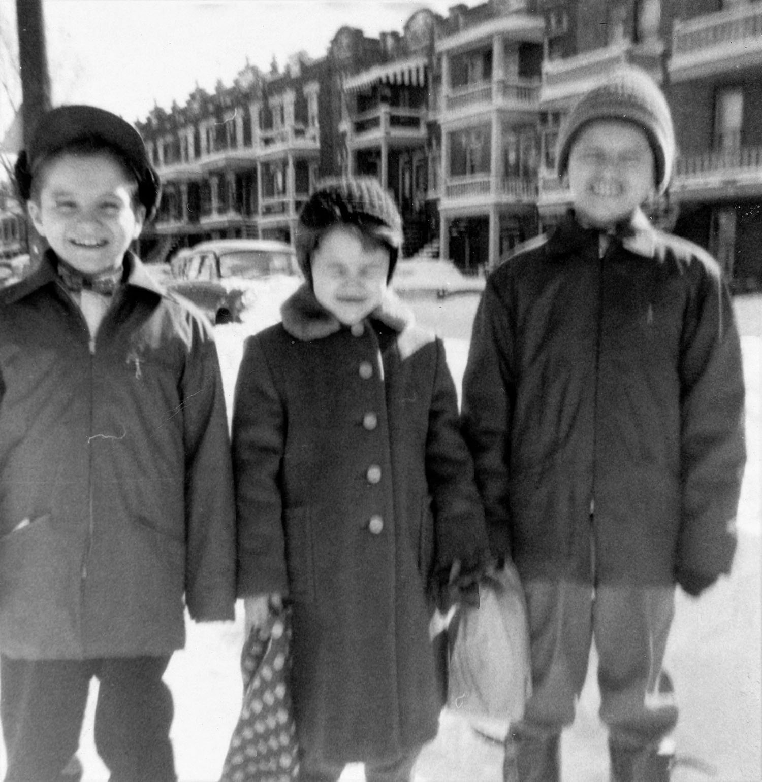 Fotografia de três crianças numa rua no inverno.