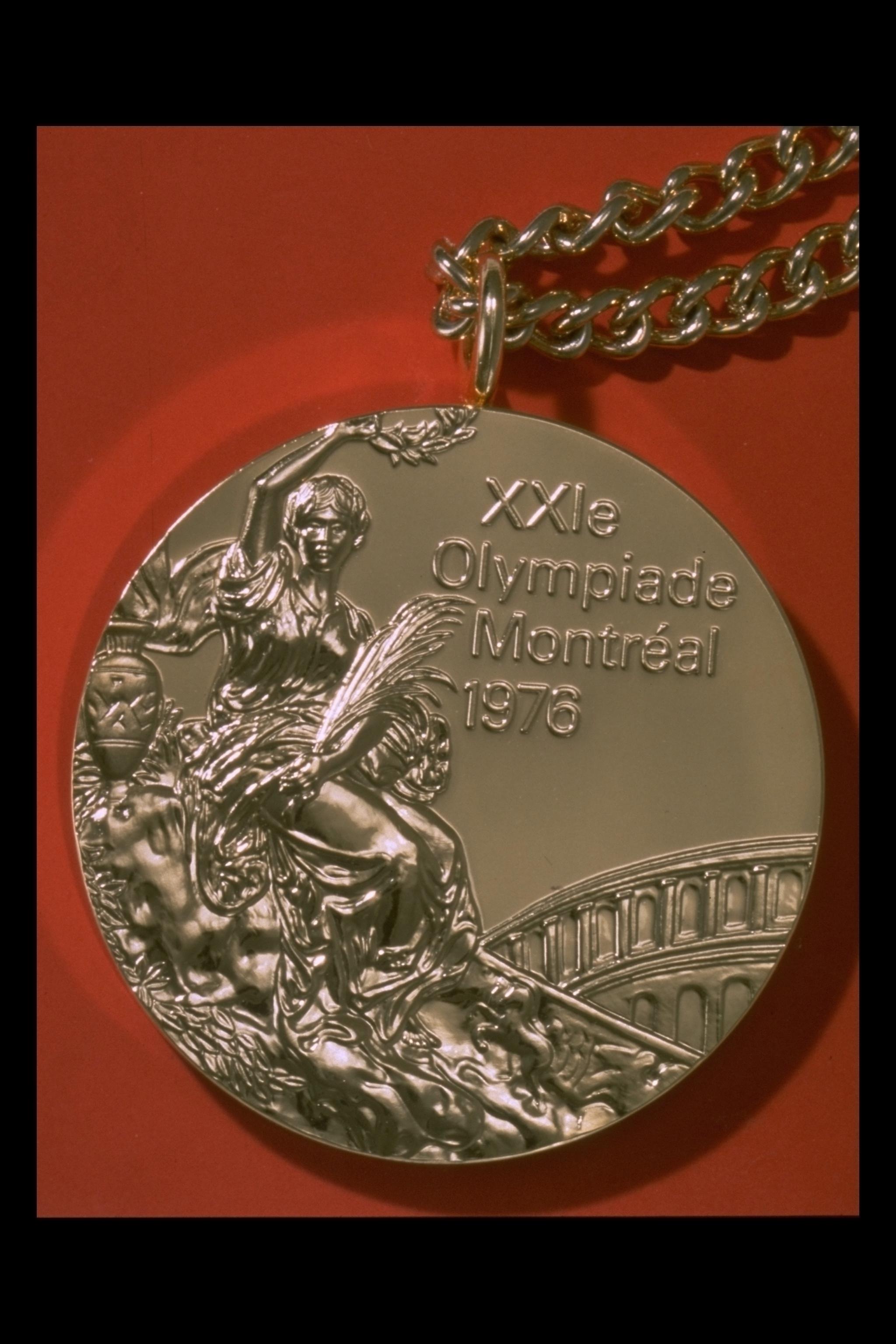Photographie d'une médaille avec chaîne, avec mention « XXIe Olympiade Montréal 1976 ».