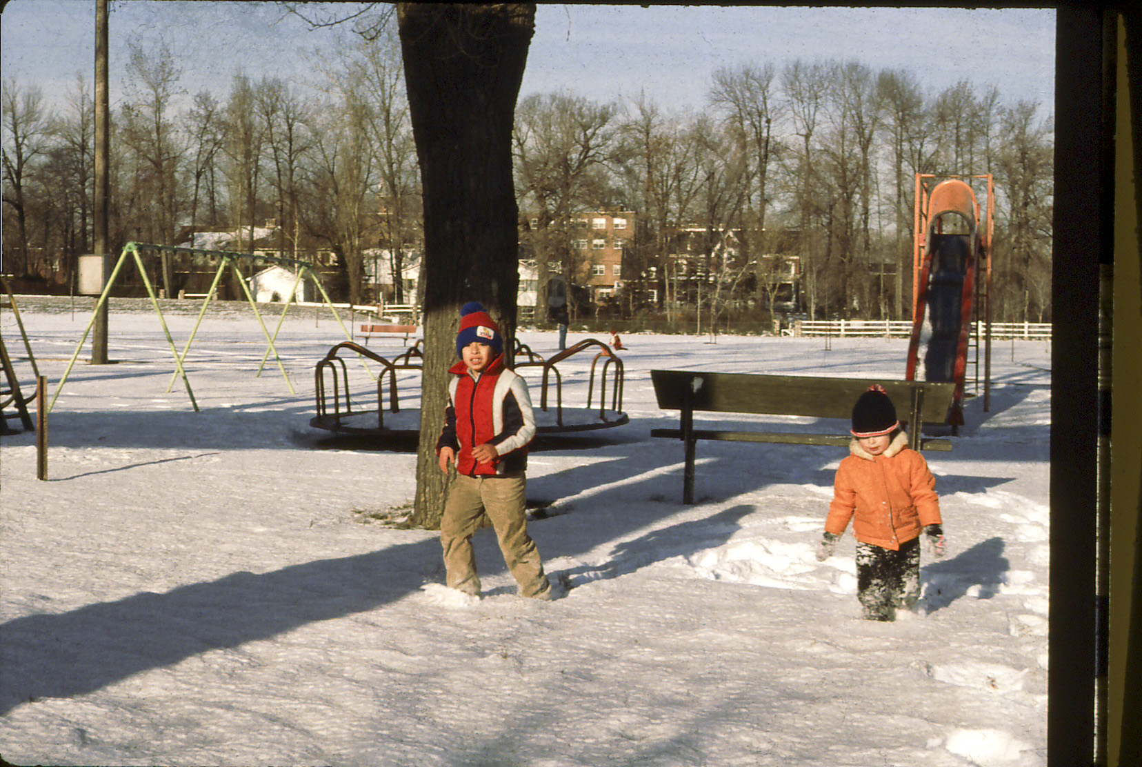 Deux enfants jouent dans la neige dans un parc