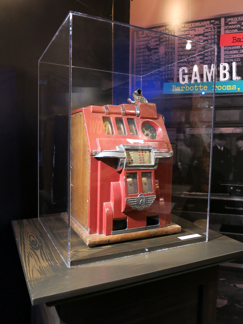 Machine à sous rouge avec détails chromés dans une vitrine dans une salle d’exposition. 