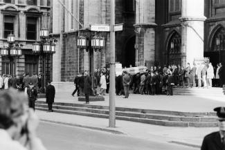Photo en noir et blanc du parvis de l’église Notre-Dame montrant l’arrivée du cercueil de Pierre Laporte. 