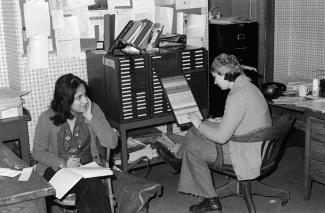 Deux femmes sont assises dans un bureau en train de travailler.