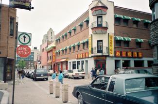 Photo couleur montrant l’intersection des rues Clark et De la Gauchetière dans le Quartier chinois. Le café Nanking est au coin de la rue.