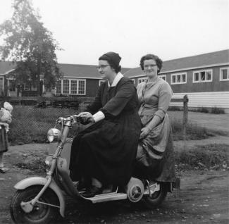 Deux femmes sur une mobylette.