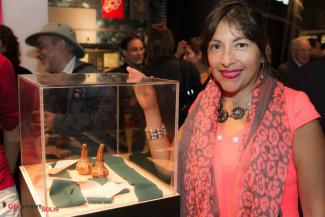 Exposition de LatinArte au Centre d'histoire de Montréal. Une femme se tient à côté d'une vitrine. 