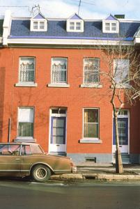 Façade d'une maison sur la rue Dézéry avec une voiture en avant-plan