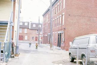 Scène de ruelle avec deux enfants et une rangée de maisons sur la droite