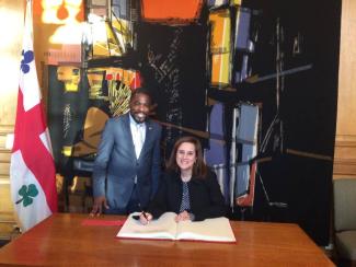 Angela Sierra signe le livre d'or de la Ville de Montréal en compagnie de Frantz Benjamin.