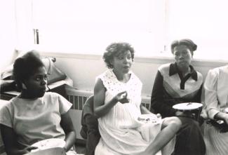 Trois femmes assises tenant une assiette lors d'une rencontre