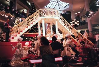 Des étalagistes préparent les personnages et décors du « Bal à Versailles » pour le centre Rockland. À l’arrière-scène, un grand escalier blanc et doré vient d’être assemblé.