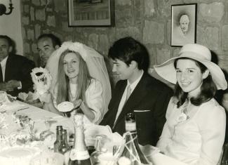 Des mariés, deux hommes à leur gauche et une jeune fille à leur droite, assis à une table
