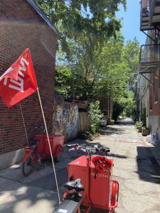 Deux vélos rouges sont stationnés dans une ruelle en été.