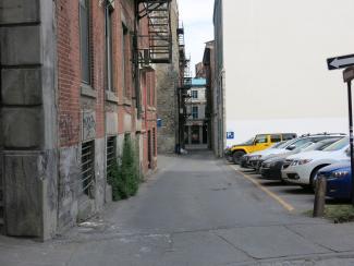 La ruelle Saint-Éloi, très étroite, avec un stationnement à droite et les façades de bâtiments à gauche.