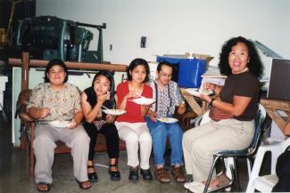 Cinq personnes d'origine philippine sont assis et mangent.