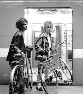 Deux jeunes filles entrent dans un wagon du métro avec leur vélo.