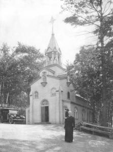Frère André devant la petite chapelle d’origine en 1921.