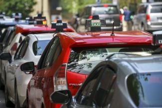Photographie en couleur d’une file de voitures de taxi en gros plan. 