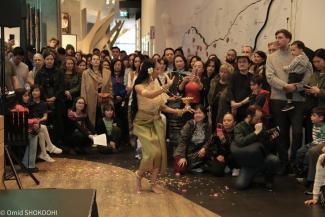 Une femme donne une prestation de danse devant une foule nombreuse.