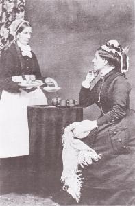 Photographie de profil d'une femme prenant le thé (à droite) et de la femme lui servant le thé (à gauche).