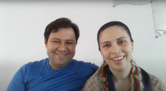 Photo en plan rapproché d’un homme et d’une femme souriant, l’homme enlace la femme.