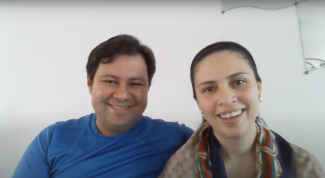 Close-up of a smiling woman and man, with his arm wrapped around her. 