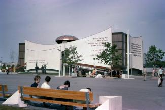Photographie couleur montrant le pavillon du judaïsme. Devant, des personnes circulent ou sont assises sur des bancs.