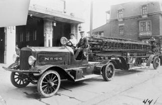 Photographie d'un camion à échelle affichant « No 44 » devant la caserne. 