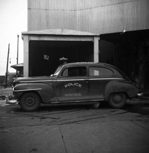 Photographie en noir et blanc d’une voiture du Service de police de Montréal.