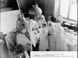 Photo en noir et blanc d’un médecin et ses assistants dans une salle d’opération