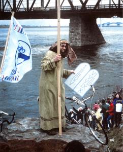Robert Silverman, déguisé en Moïse, tente de séparer les eaux du fleuve pour gagner l'accès cyclable à la Rive-Sud de Montréal