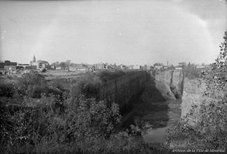 Photographie de la carrière Martineau et Rogers située au coin de la rue de Bellechasse et de l'avenue Papineau à Montréal. On y voit les bâtiments environnants.