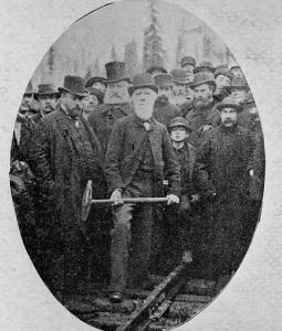 Donald Smith, de la compagnie de chemin de fer Canadien Pacifique, enfonce le dernier crampon de la voie de la première ligne ferroviaire transcontinentale du pays. William Van Horne est à côté de Donald Smith au centre gauche.