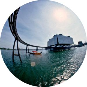 Photo fisheye montrant le pavillon du Québec avant de l'eau à l'avant-plan et le minirail