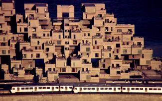 Vue d’ensemble du complexe Habitat 67 avec le train Expo Express devant.