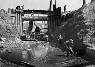 Photo en noir et blanc montrant des ouvriers qui travaillent à la construction d’un égout.