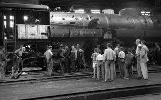 Vue latérale d'une locomotive avec le groupe en visite.