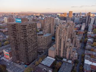 Photo couleur prise par un drone montrant un quartier du centre-ville de Montréal densément construit avec plusieurs tours.