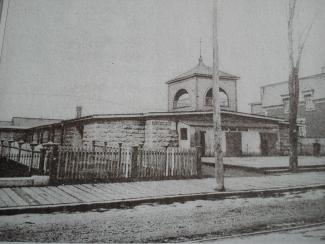 Photo ancienne d'un bâtiment coiffé d'un clocher de chapelle.