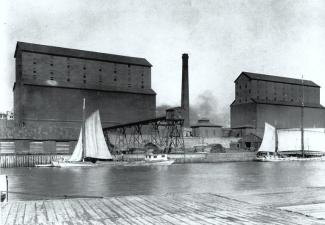 Photographie de biais du silo-élévateur et d'embarcations sur l'eau.