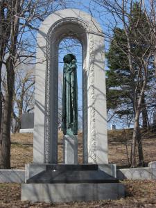 Photographie d'une statue de madone encadrée d'une arche ouvragée.