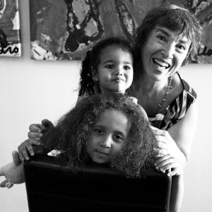 Photo en noir et blanc montrant une grand-mère et ses deux petites-filles, l’une derrière l’autre en plan rapproché.